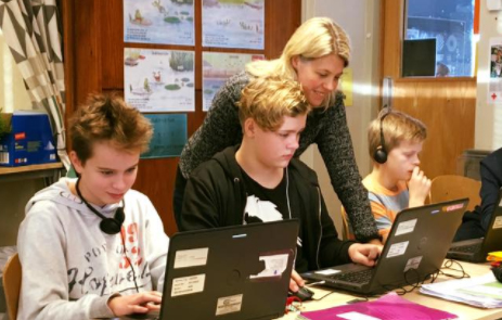 Elever som arbetar med digitala läromedel i ett klassrum